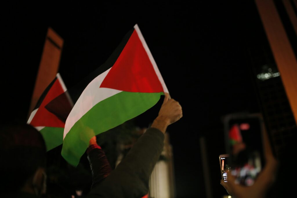 Person holding a Palestinian flag (black, red, white and green)